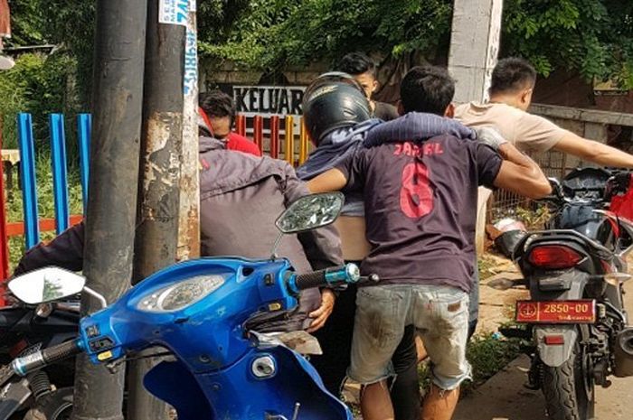 Seorang wanita pengendara motor hilang keseimbangan dan menabrak pagar besi rumah makan ketika melintas di Jalan Abdul Wahab, Cinangka, Kedaung, Sawangan, Depok
