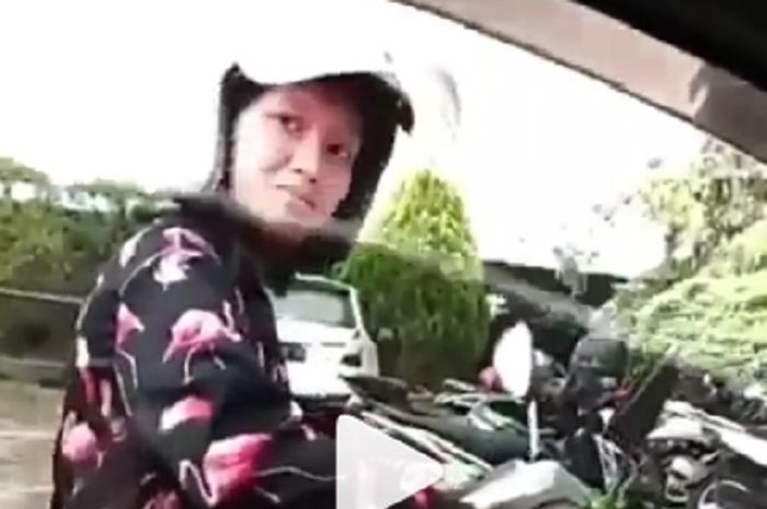 Pengendara motor wanita ini bercermin di kaca mobil orang