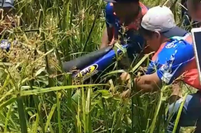 Beberapa orang berhasil 'menangkap' motor bebek di rawa berair keruh di Sulawesi Tenggara