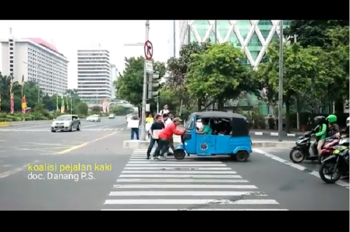 Sebuah bajaj yang berhenti di zebra croos didorong mundur