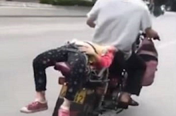 Seorang pria tega mengikat anaknya di jok motor