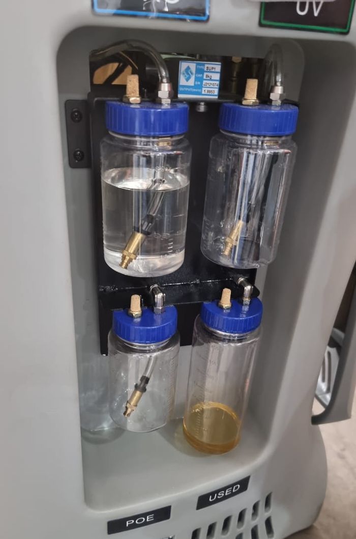 Oli kompresor AC yang sudah lama dipakai akan berubah jadi kuning (tabung paling kanan bawah). Sedangkan yang baru berwarna bening (tabung kiri atas)