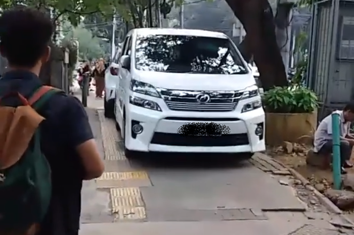 Mobil mewah parkir di atas trotoar jalan