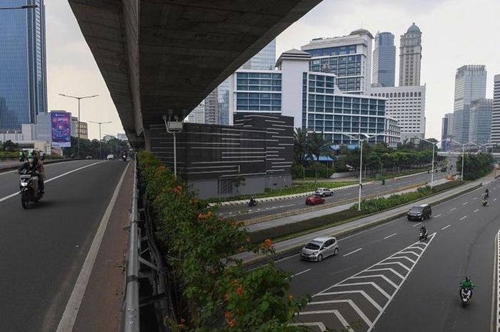 Pengendara melintasi kawasan jalan Sudirman yang lengang di Jakarta, Minggu (27/6/2021). Jakarta termasuk pada daerah sasaran PPKM Darurat. ANTARA FOTO/Wahyu Putro A/aww.(ANTARA FOTO/WAHYU PUTRO A)