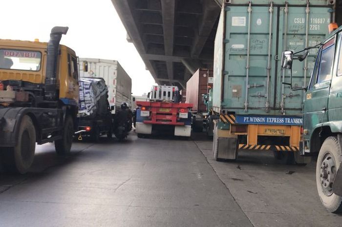 ILUSTRASI. Sopir truk kontainer kasih cara ke pengendara motor agar bisa menyalip dengan aman.