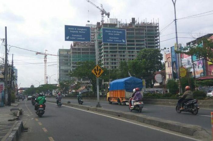 Papan peraturan larangan melintas di jalur cepat untuk angkot dan sepeda motor di Margonda Raya, Depok, Jawa Barat.