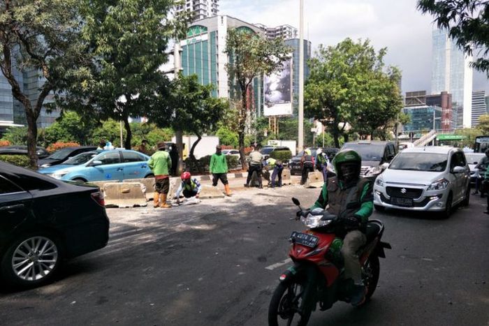 Petugas membersihkan sisa balok yang hancur setelah ditabrak Minitrans hingga terguling di Jl Gatot 