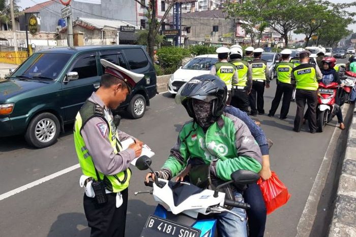 Seorang pengendara sepeda motor ditilang polisi saat terjaring Operasi Zebra di Jalan Margonda Depok, Kamis (1/11/2018)