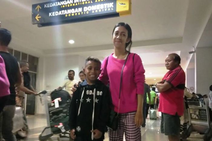 Dady Sopbaba, bocah yang meniru komentator MotoGP Nick Harris, bersama tantenya Yuli Masiweni, saat tiba di Bandara El Tari Kupang, Senin (5/11/2018)