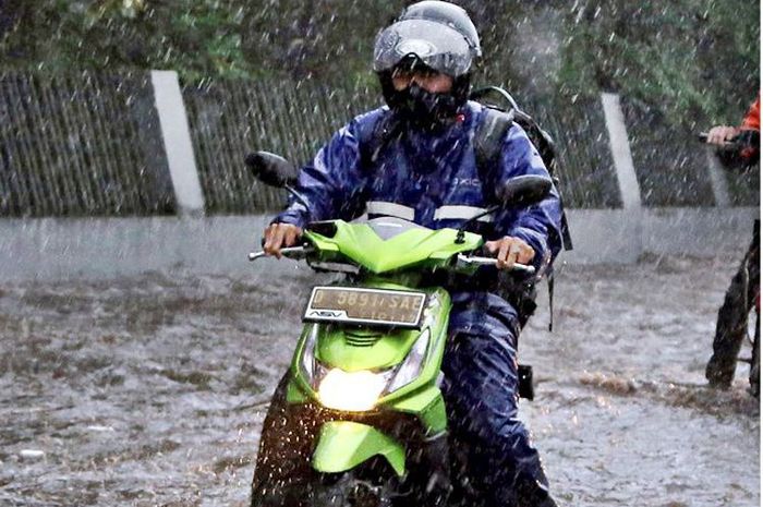 Ilustrasi bikers naik motor kondisi hujan deras.