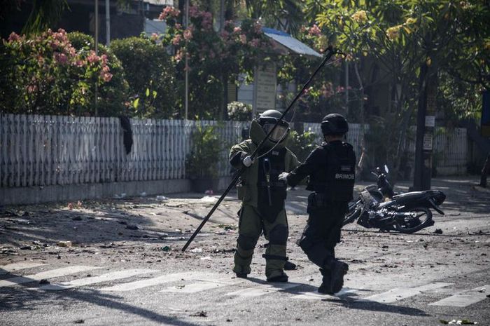 Anggota penjinak bom memeriksa lokasi ledakan bom di gereja di Surabaya, Minggu (13/5/2018). 
