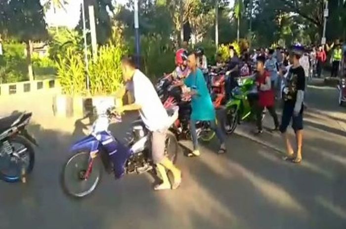 Pelaku balap liar yang terjaring razia harus mendorong motor menuju ke kantor polisi