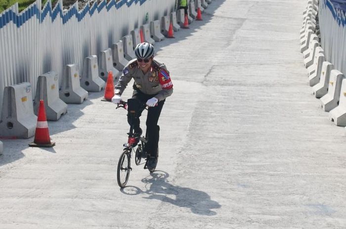 Kakorkantas Polri Irjen Pol Royke Lumowa mengayuh sepeda lipat kecil melintasi tanjakan jembatan Kal