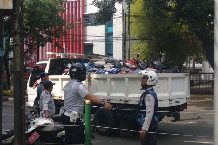 Sejumlah sepeda motor yang parkir di trotoar DPRD DKI di Jalan Kebun Sirih, Jakarta Pusat, diangkut Dishub DKI, (22/6/2018).