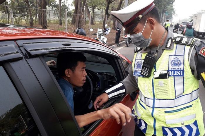 Pengendara ditilang polisi di Jalan Benyamin Sueb, Jakarta Utara, karena melanggar aturan ganjil-genap