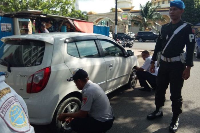 Aparat setempat mengempiskan ban mobil yang parkir sembarangan