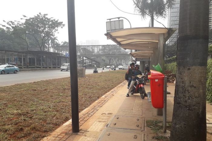 Halte bus di depan Gedung Graha CIMB Niaga, Jalan Jenderal Sudirman, yang aksesnya terhalang area rerumputan, Selasa (24/7/2018).(KOMPAS.com/Ardito Ramadhan D)