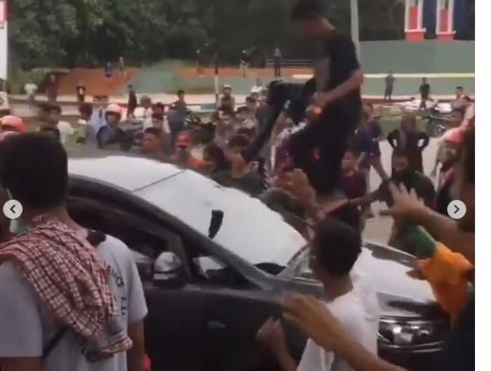 Salah satu oknum massa demo merusak kaca depan Toyota Kijang Innova