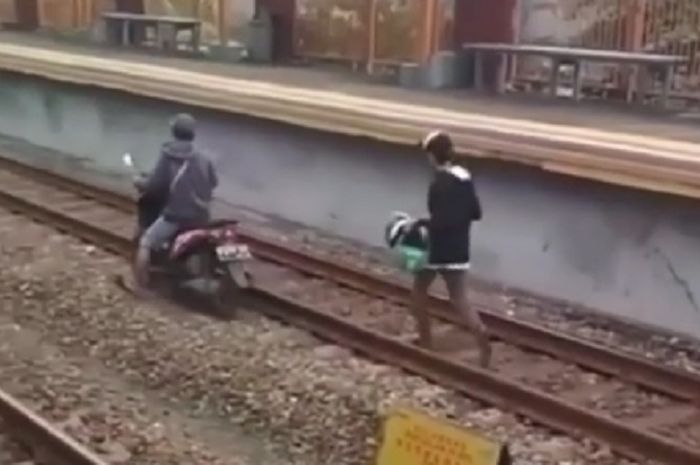 Kids zaman now nekat naik motor di rel kereta api, bahaya banget.