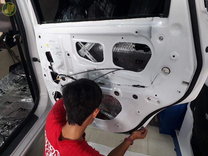 Proses pemasangan peredam di pintu mobil