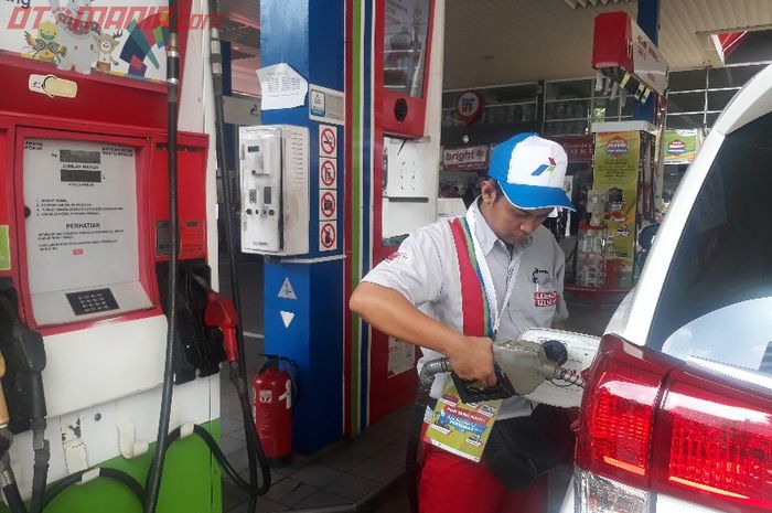 Ilustrasi petugas SPBU Pertamina tengah mengisi BBM ke mobil konsumen