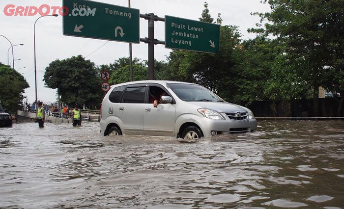 Ilustrasi mobil melewati banjir