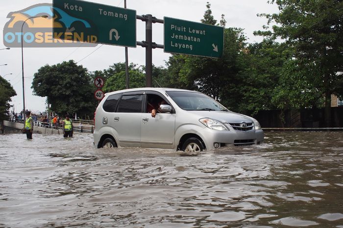 Ilustrasi mobil melewati banjir