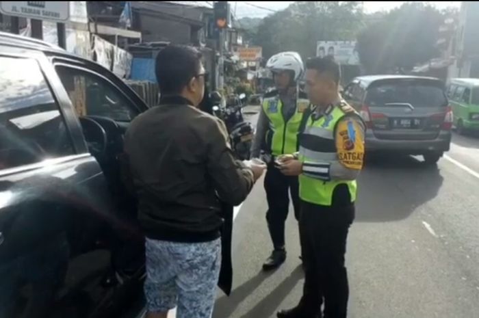 Petugas menilang Toyota Fortuner  di kawasan Puncak