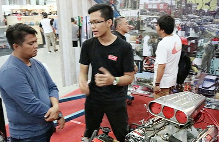 Icang, mahasiwa magang menjelaskan seluk belul mesin V8 kepada pengunjung pameran