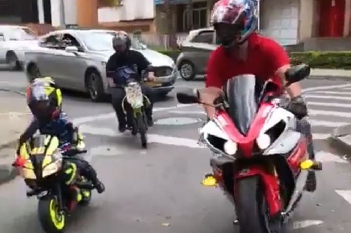 Kompak ayah dan anak naik motor berdampingan