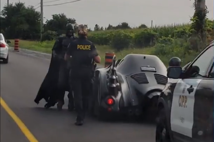 Batman dan polisi sedang berbincang di jalanan