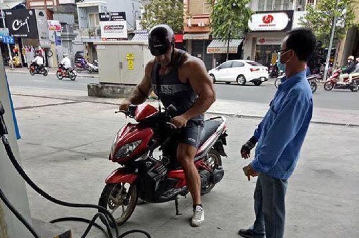 Seorang pria kekar sedang mengisi bahan bakar