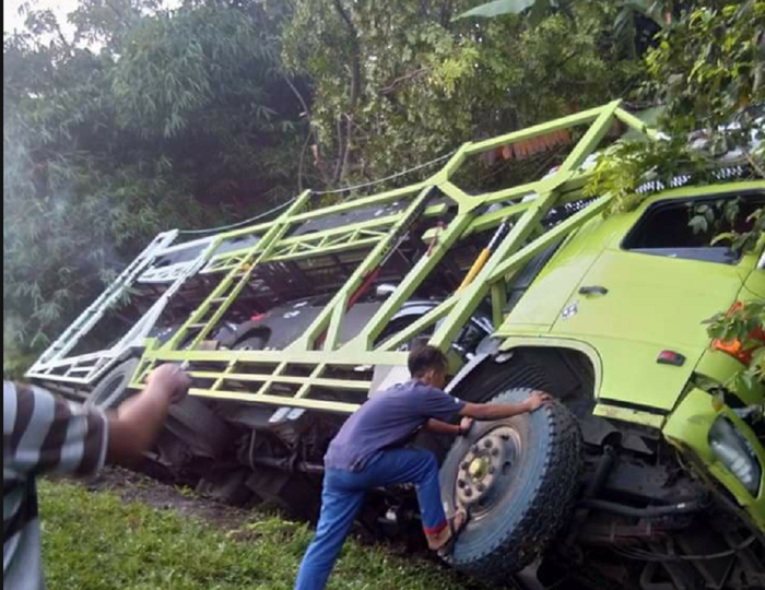 Truk pengangkut Xpander dan Pajero terguling di parit.