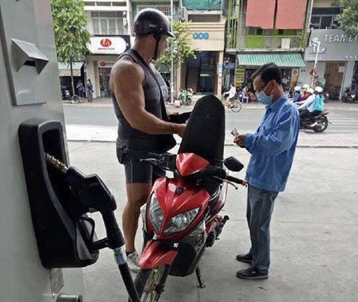 Seorang pria kekar sedang mengisi bahan bakar