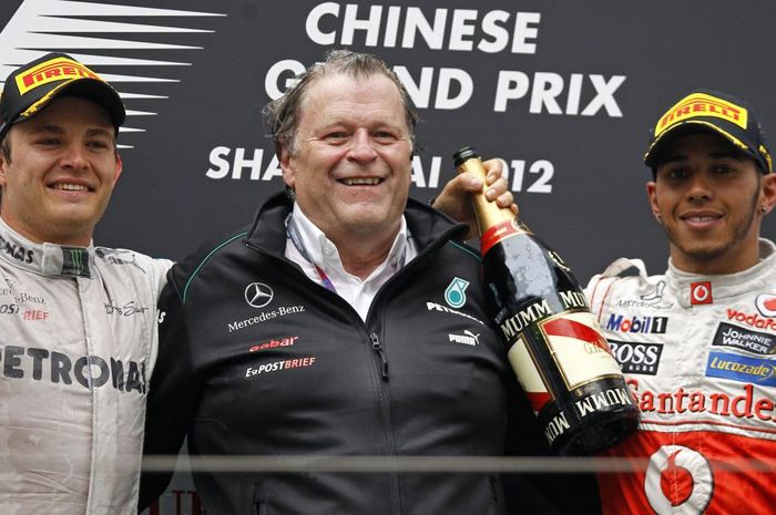 Norbert Haug di antara pembalap tim Mercedes Nico Rosberg dan Lewis Hamilton yang balapan untuk tim McLaren bermesin Mercedes