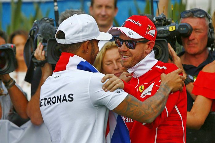 Lewis Hamilton (kiri) mendapat ucapan selamat dari rival beratnya Sebastian Vettel ketika dikukuhkan sebagai juara dunia F1 2017 di GP F1 Meksiko