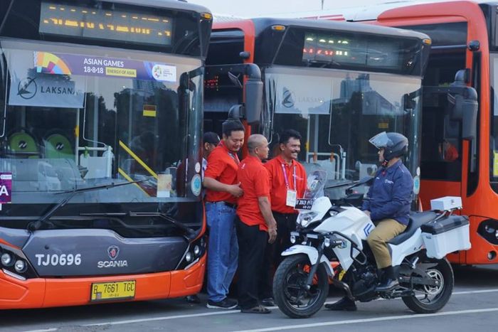 Foto Anies Baswedan berada di depan bus TransJakarta bermerek Scania