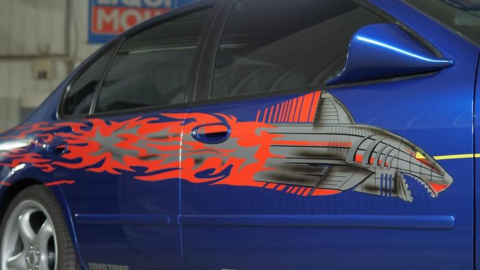 Kelir biru metalik dan decal hiu mengias bodi Nissan Maxima