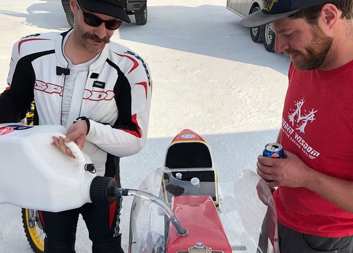 Ryan Montgomery (kiri) mengisi vodka pada Yamah XS650