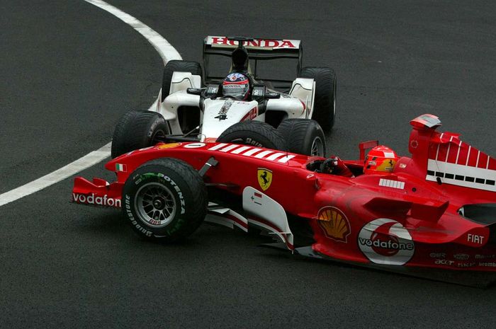 Pembalap Jepang Takuma Sato dengan mobil BAR-Honda menyundul mobil Ferrari andalan Michael Schumacher di GP F1 Belgia 2005