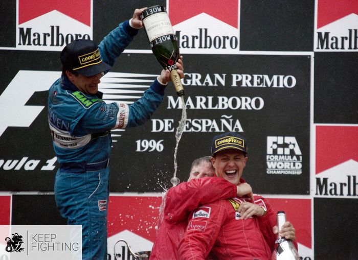 Michael Schumacher dipeluk bos tim Ferrari, Jean Todt di podium F1 Spanyol 1996, pembalap Benetton Jean Alesi yang finish kedua menyiram sampanye