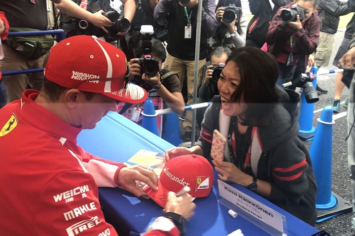 Seorang wanita menjerit histeris di depan Kimi Raikkonen ketika topinya ditandatangani pembalap Ferrari ini