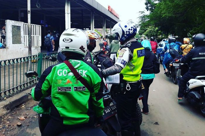 Pihak kepolisian melakukan tilang kepada pengemudi ojek online yang sembarang mangkal di Stasiun Manggarai, Jakarta Selatan