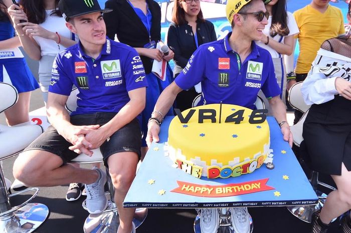 Valentino Rossi berpose dengan kue HUT-nya didampingi rekan satu timnya, Maverick Vinales