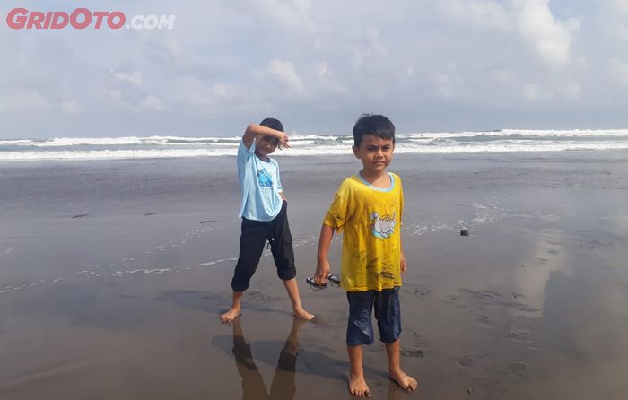 Anak-anak pose riang di area pantai Cemara