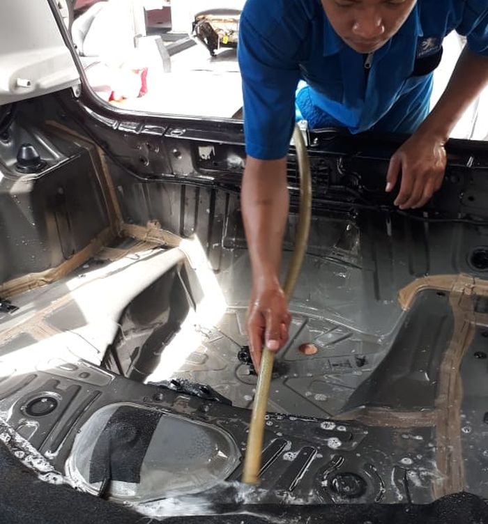 Mekanik Astra Peugeot membersihkan ruang kabin karena banjir