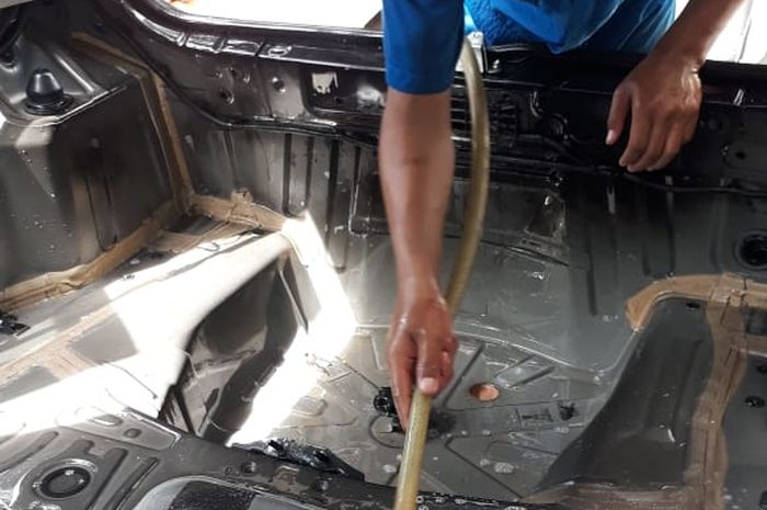 Mekanik Astra Peugeot membersihkan ruang kabin karena banjir