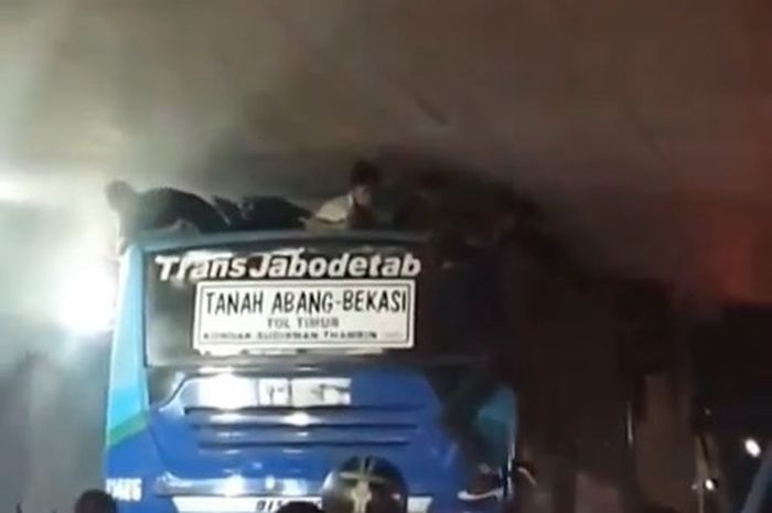 Sekelompok pemuda terhimpit langit-langit terowongan dan atap bus di terowongan Tanah Abang, Jakarta Pusat.