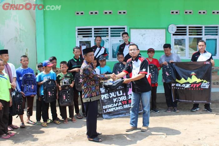 Velozity menyerahkan bantuan kepada kepala sekolah MTs Nurul Islam, Lampung