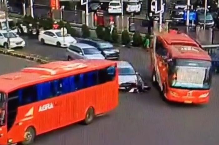 Kecelakaan motor tersenggol mobil dan jatuh di dekat bus yang melintas